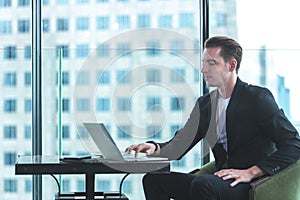 Businessman using tablet computer to work with financial data in the modern office, relax and rest time after work.