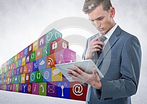 Businessman using tablet with icon block in background