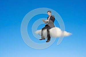 Businessman using tablet and sitting on cloud