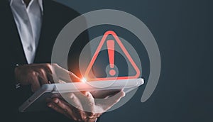 Businessman using tablet with triangle caution warning sing for notification error and maintenance concept