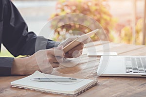 Businessman using tablet working with laptop and cell phone.