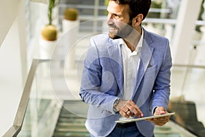 Businessman using touchscreen tablet in modern office