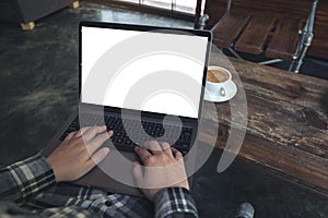 Businessman using and typing on laptop with blank white desktop screen while sitting on a chair