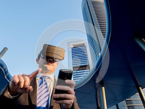 Businessman using virtual reality glasses with a mobile phone in