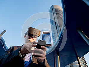 Businessman using virtual reality glasses with a mobile phone in