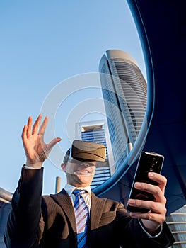 Businessman using virtual reality glasses with a mobile phone in