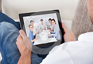 Businessman on a video call chatting to colleagues