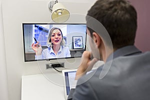 Businessman on video conference with her colleague in office job photo