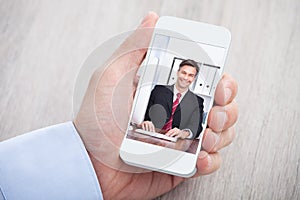 Businessman video conferencing with colleague at desk