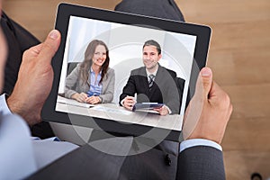 Businessman video conferencing with colleagues on digital tablet