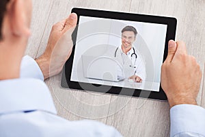 Businessman video conferencing with doctor on digital tablet