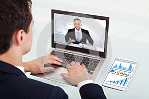 Businessman video conferencing on laptop in office