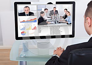 Businessman video conferencing with team