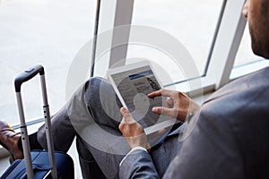 Businessman Viewing Boarding Pass In Airport Lounge