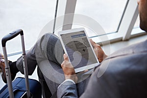 Businessman Viewing Boarding Pass In Airport Lounge