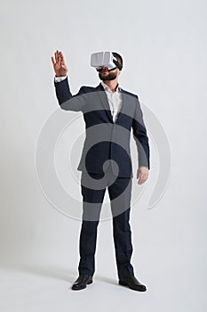 A businessman in virtual reality glasses touches something