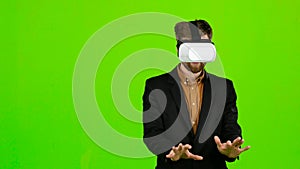 Businessman in virtual reality is having fun and smiling. Green screen