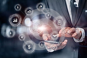 Businessman on virtual screen works with structure of business icons