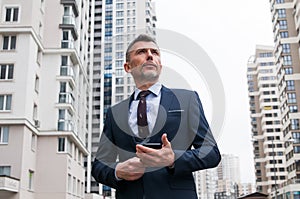 businessman walking along the street with suitcase. Senior businessman walking in modern office building. Successful business man