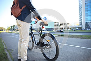 Businessman walking with bike in street after work.