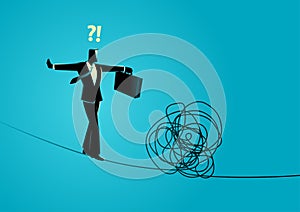 Businessman walking cautiously on a rope and facing a tangled rope in front of him