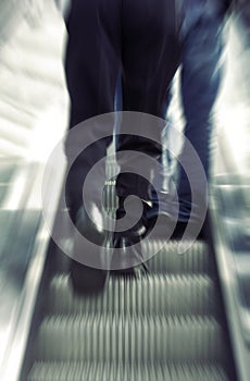 Businessman walking on escalator