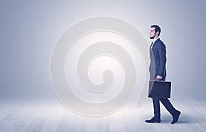 Businessman walking in front of an empty wall