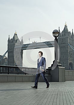 Businessman Walking In Front Of London Bridge