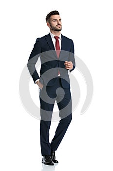 Businessman walking with hand in pocket and posing tough