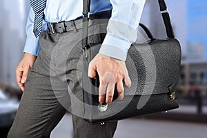 Businessman walking and holding a leather briefcase in his han