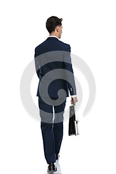businessman walking, looking away and holding briefcase