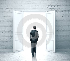 Businessman walking in open door