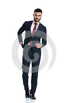 Businessman walking while pulling hand out of pocket