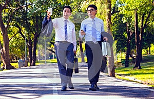 Businessman,They are walking on road in park.They are talking  business.