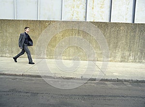 Businessman Walking On Sidewalk photo