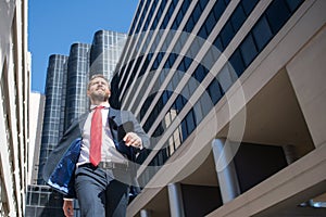Businessman walking on the street. Business man walk near modern business center. Business and architecture concept.