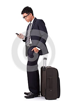 Businessman walking with suitcase and using smartphone