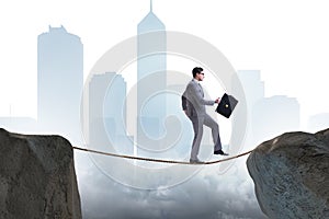 The businessman walking on tight rop in business concept