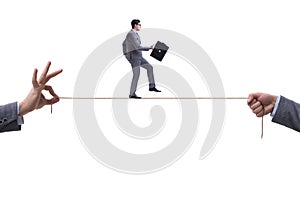 The businessman walking on tight rope in business concept