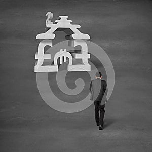 Businessman walking toward money symbol stacking building