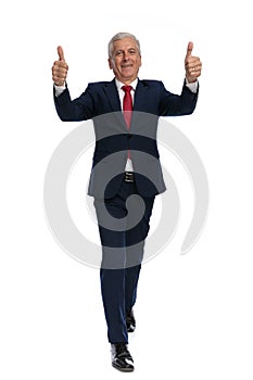 Businessman walking towards the camera and giving a thumbs up