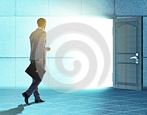 Businessman walking towards open door