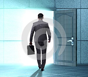 Businessman walking towards open door