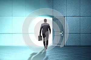 The businessman walking towards open door