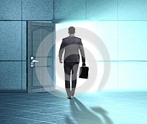 Businessman walking towards open door