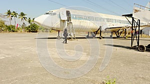 Businessman walking towards plane or airplane on airport boarding on private jet outdoors on a sunny day with clear blue sky