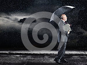 Businessman Walking Under Umbrella In Rain