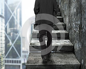 Businessman walking up the old concrete stairs