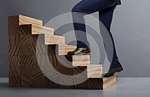 Businessman walking up stairs against grey background, closeup. Career ladder concept