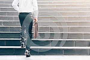 Businessman walking up on stairs and holding briefcase.